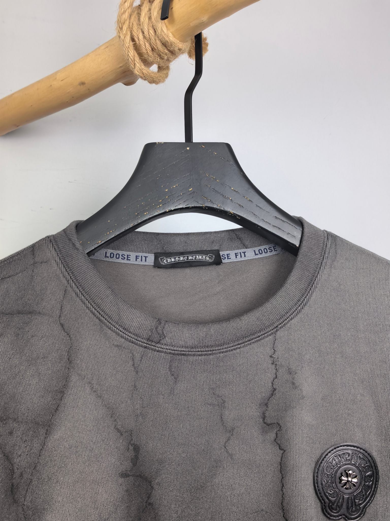 Crewneck sweatshirt with ribbed collar and marble texture; round chest logo patch