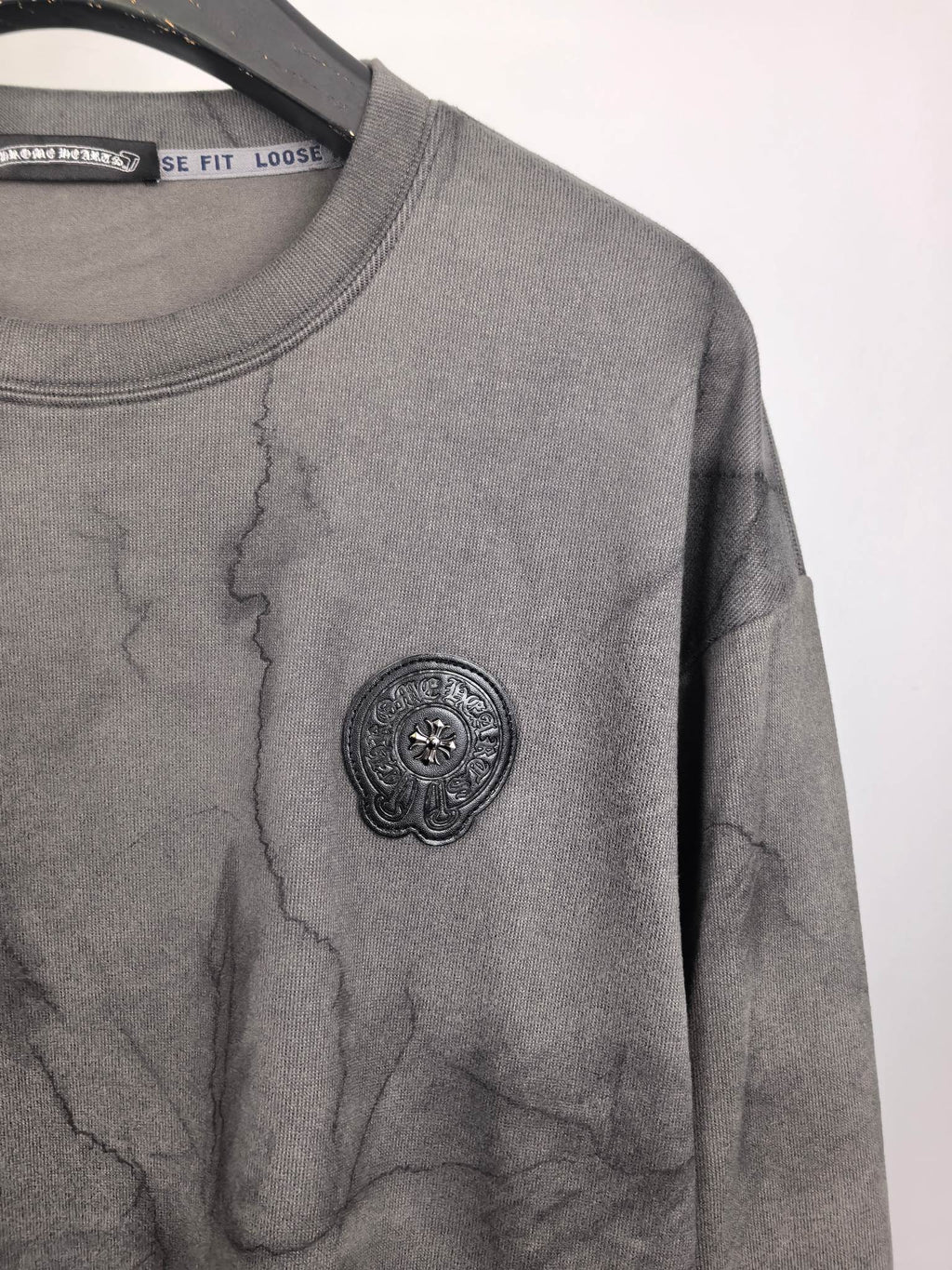 Dark gray marble crewneck sweatshirt with round embossed-style logo on chest