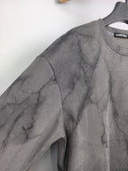 Dark gray marble print long-sleeve sweatshirt, angled view of sleeve and shoulder