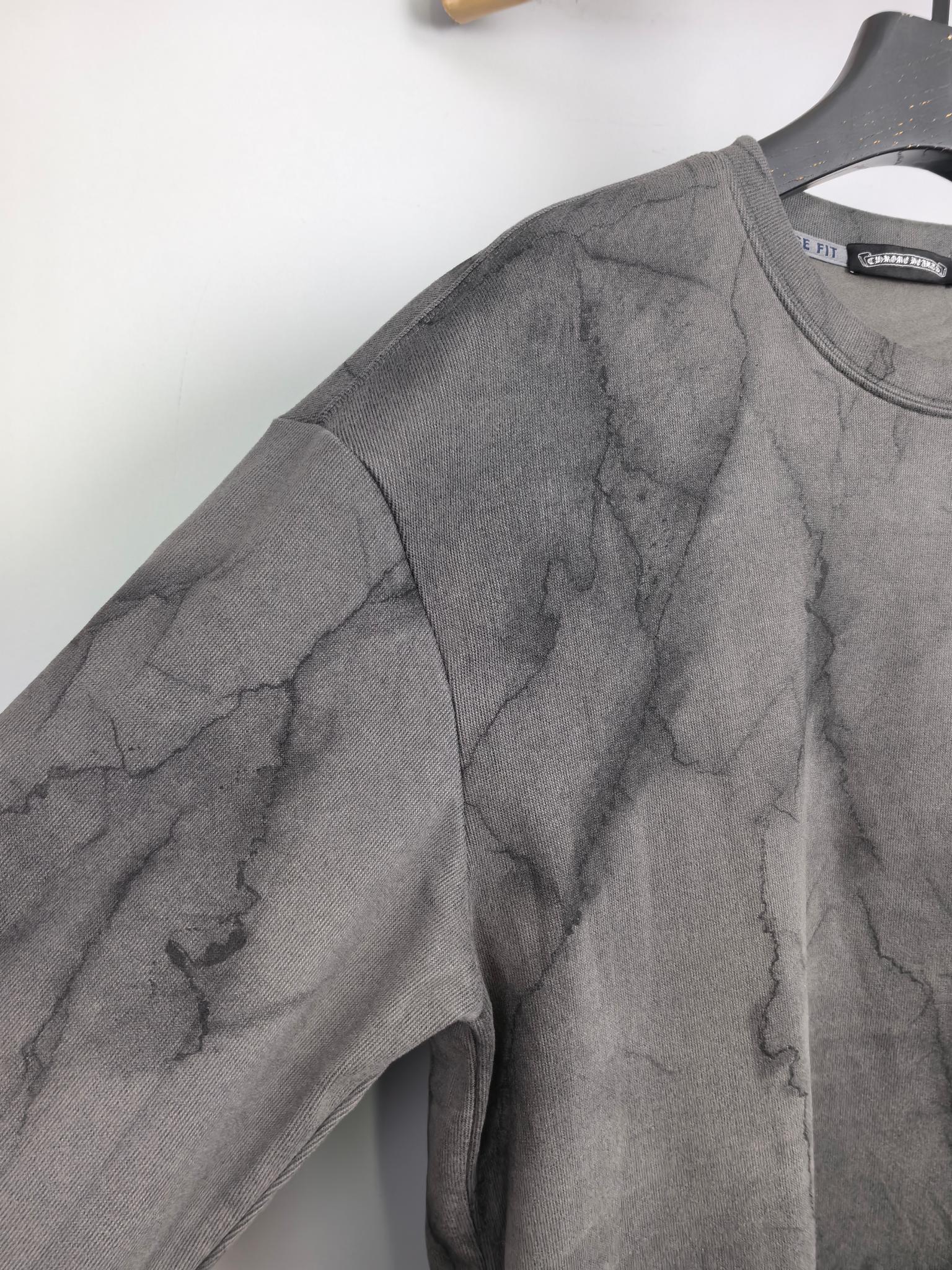 Dark gray marble print long-sleeve sweatshirt, angled view of sleeve and shoulder