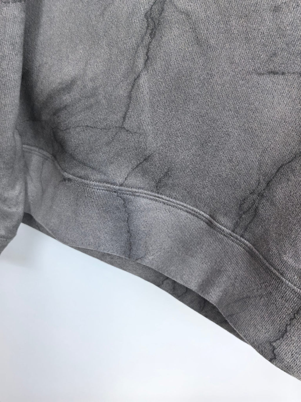Dark gray marble print sweatshirt hem with ribbed band and curved stitching