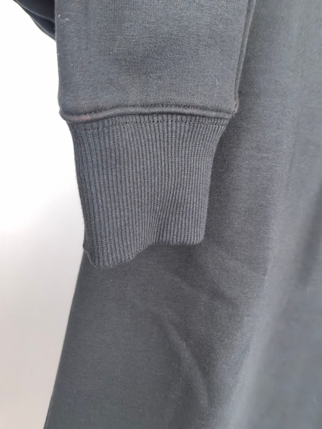 Dark gray hoodie sleeve cuff with ribbed knit hem