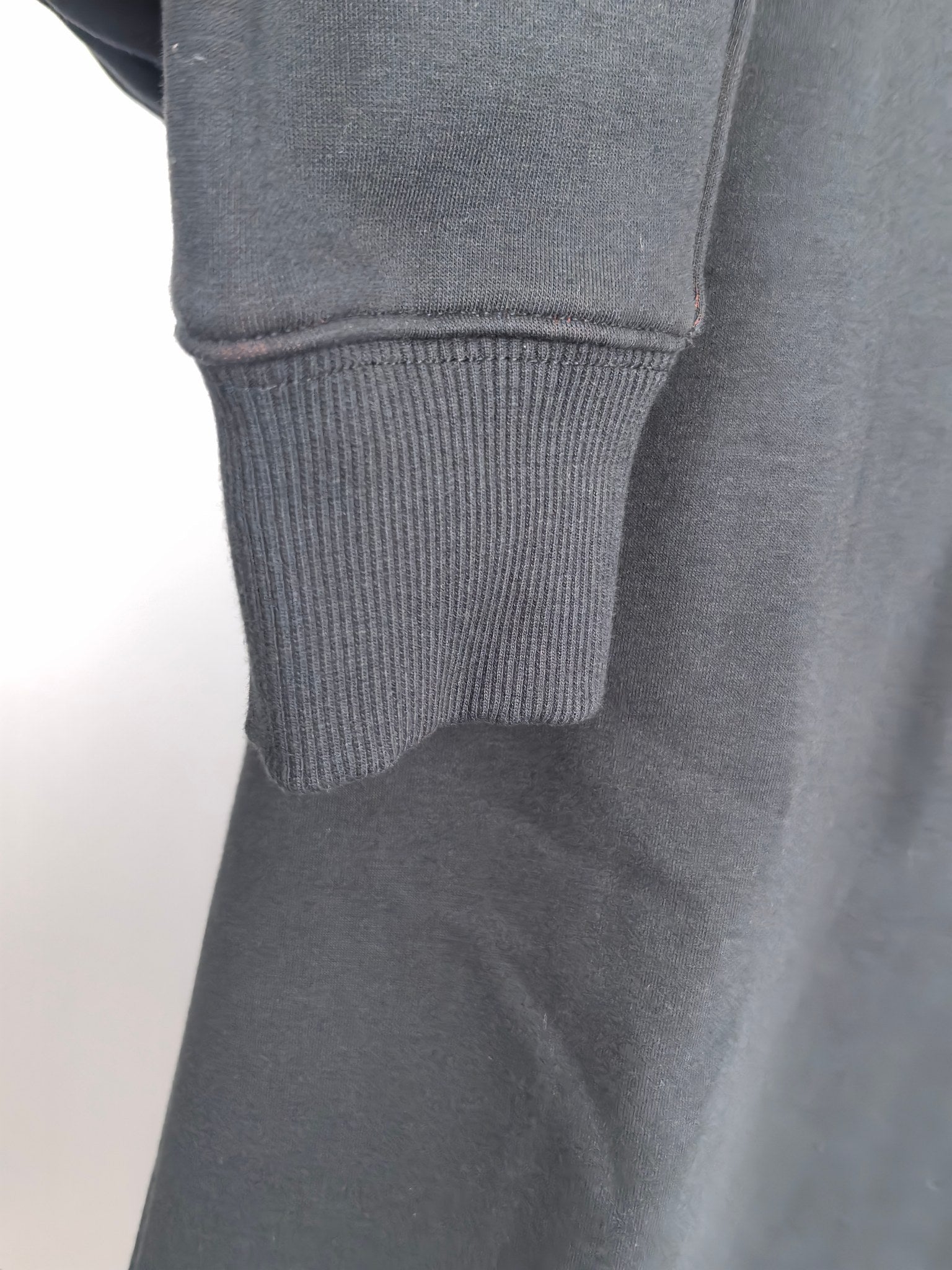 Dark gray hoodie sleeve cuff with ribbed knit hem
