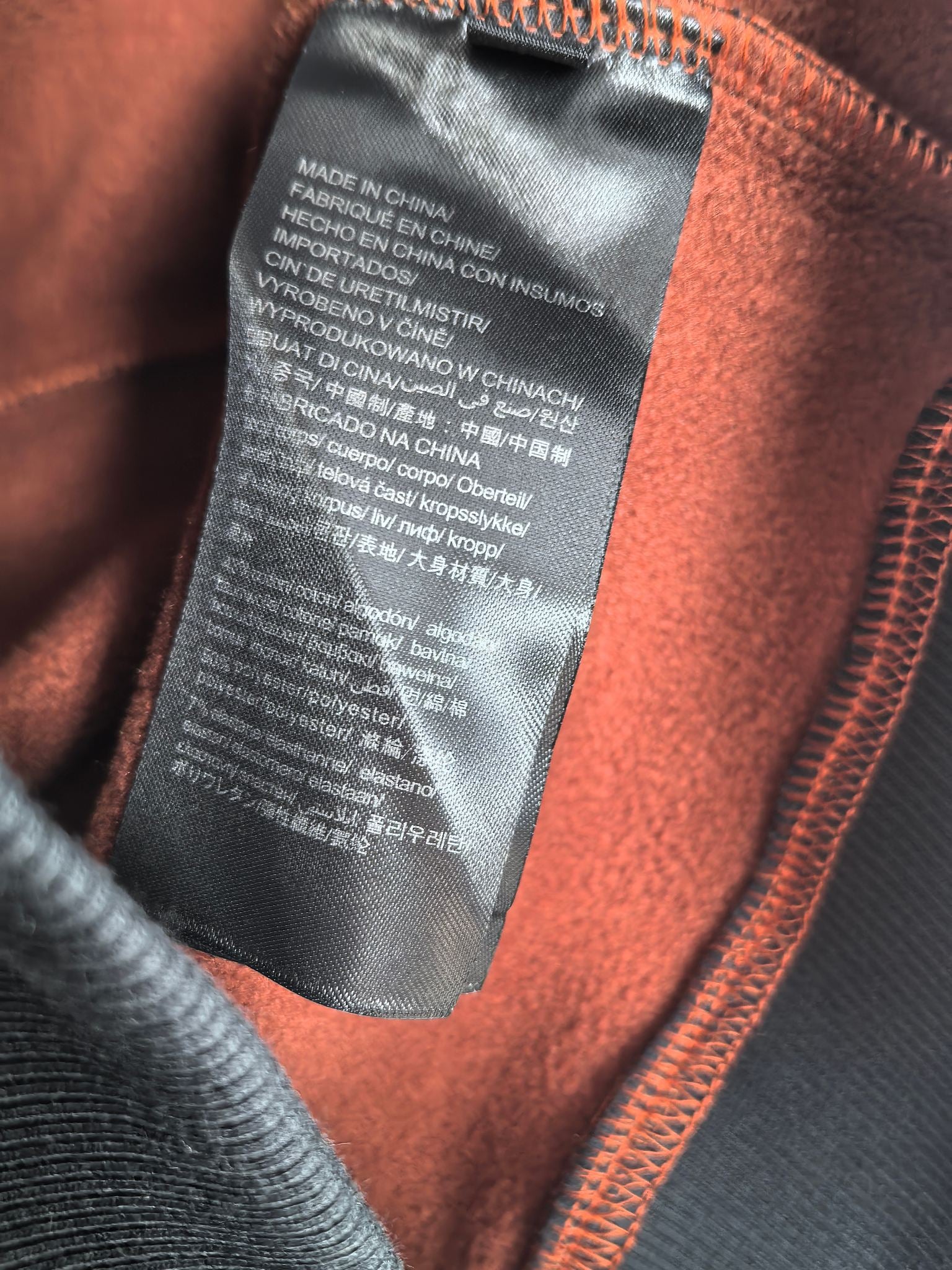 Burberry hoodie interior care label with orange fabric lining near zipper