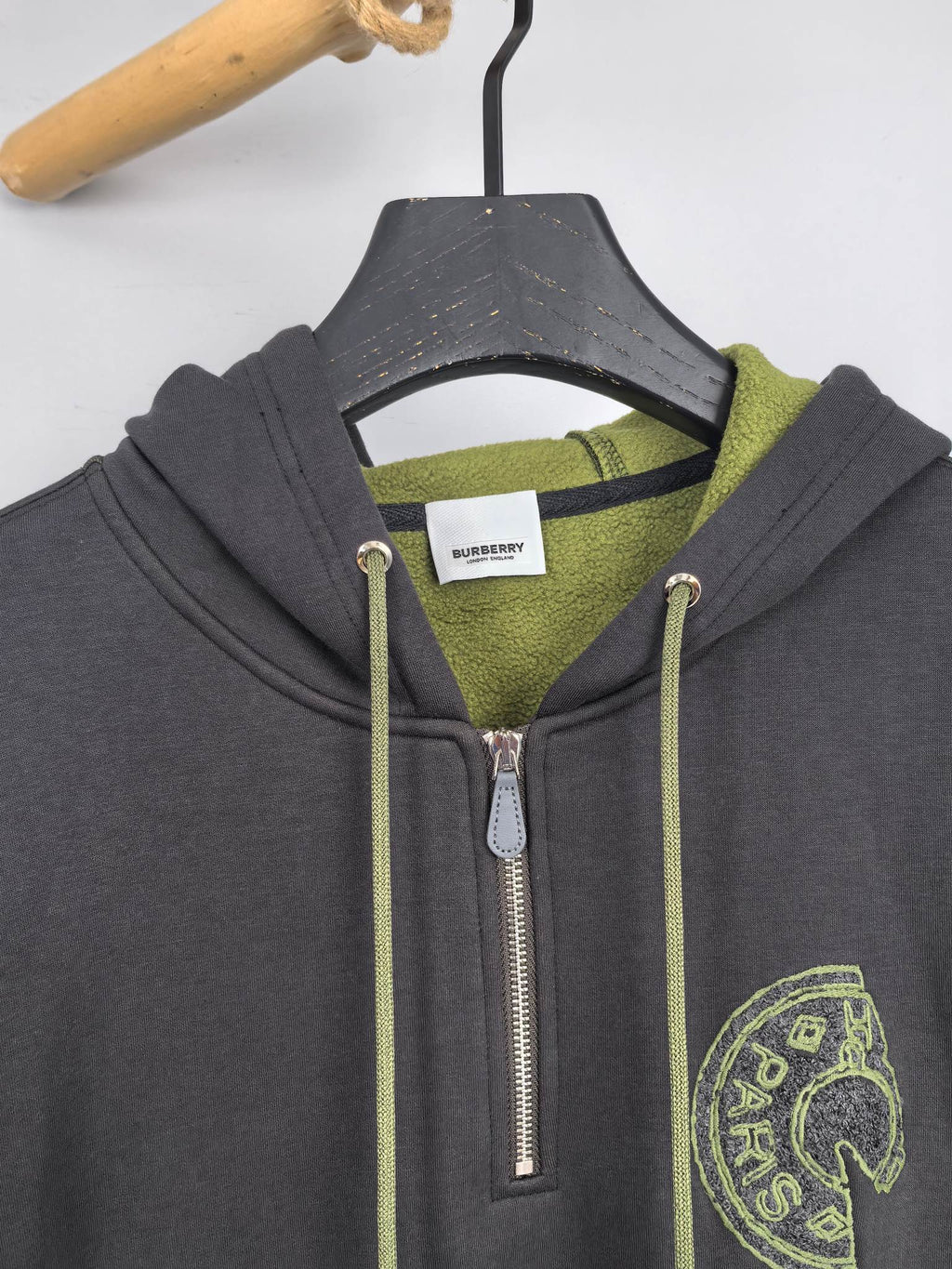 Dark gray zip-up hoodie close-up with neon green hood lining and front zipper