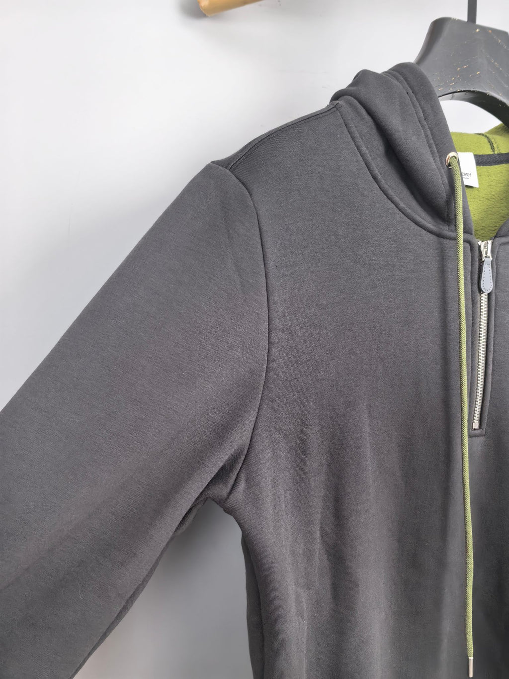 Dark gray zip-up hoodie side view with front zipper and neon green drawstring trim
