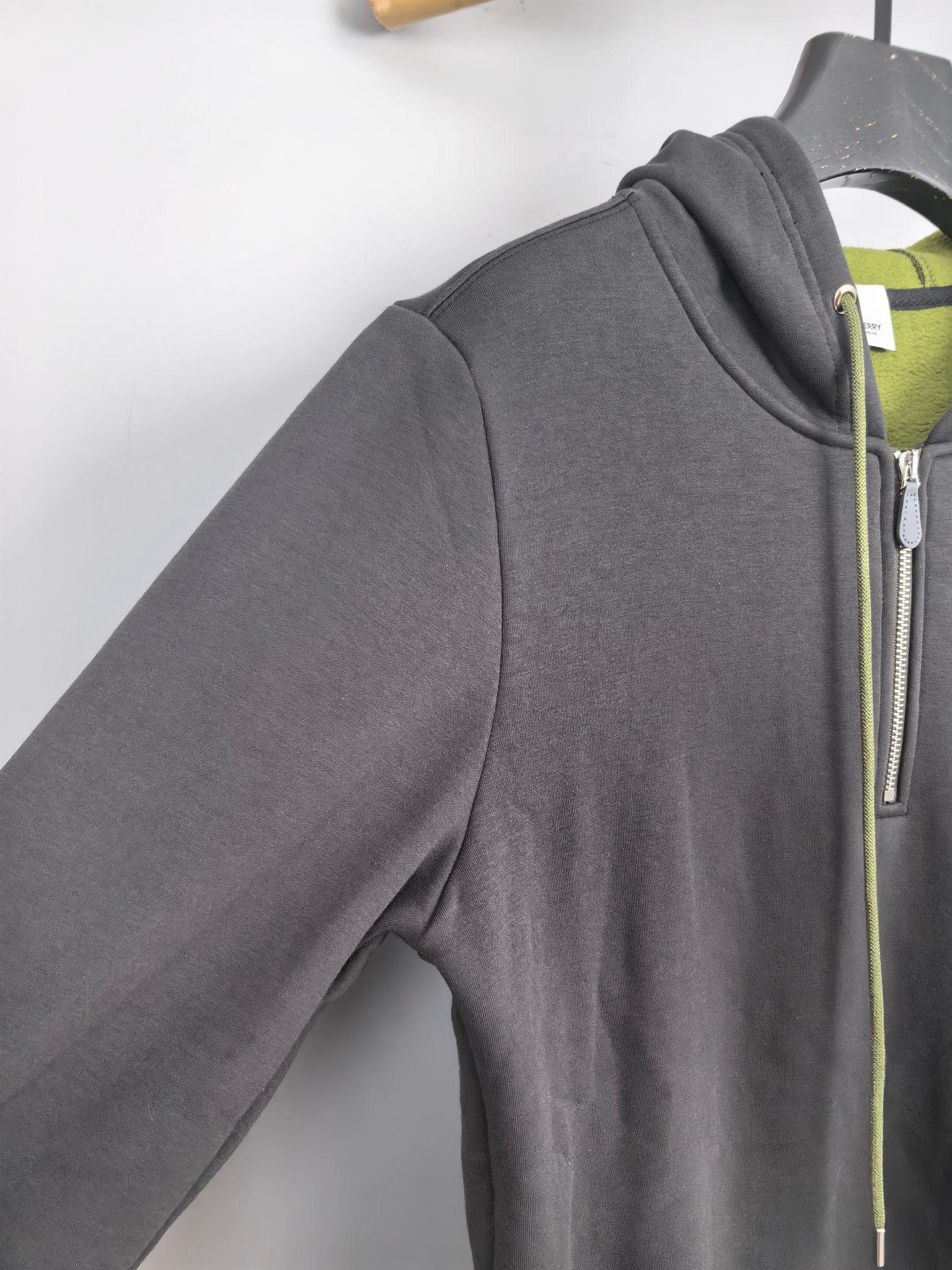 Dark gray zip-up hoodie side view with front zipper and neon green drawstring trim