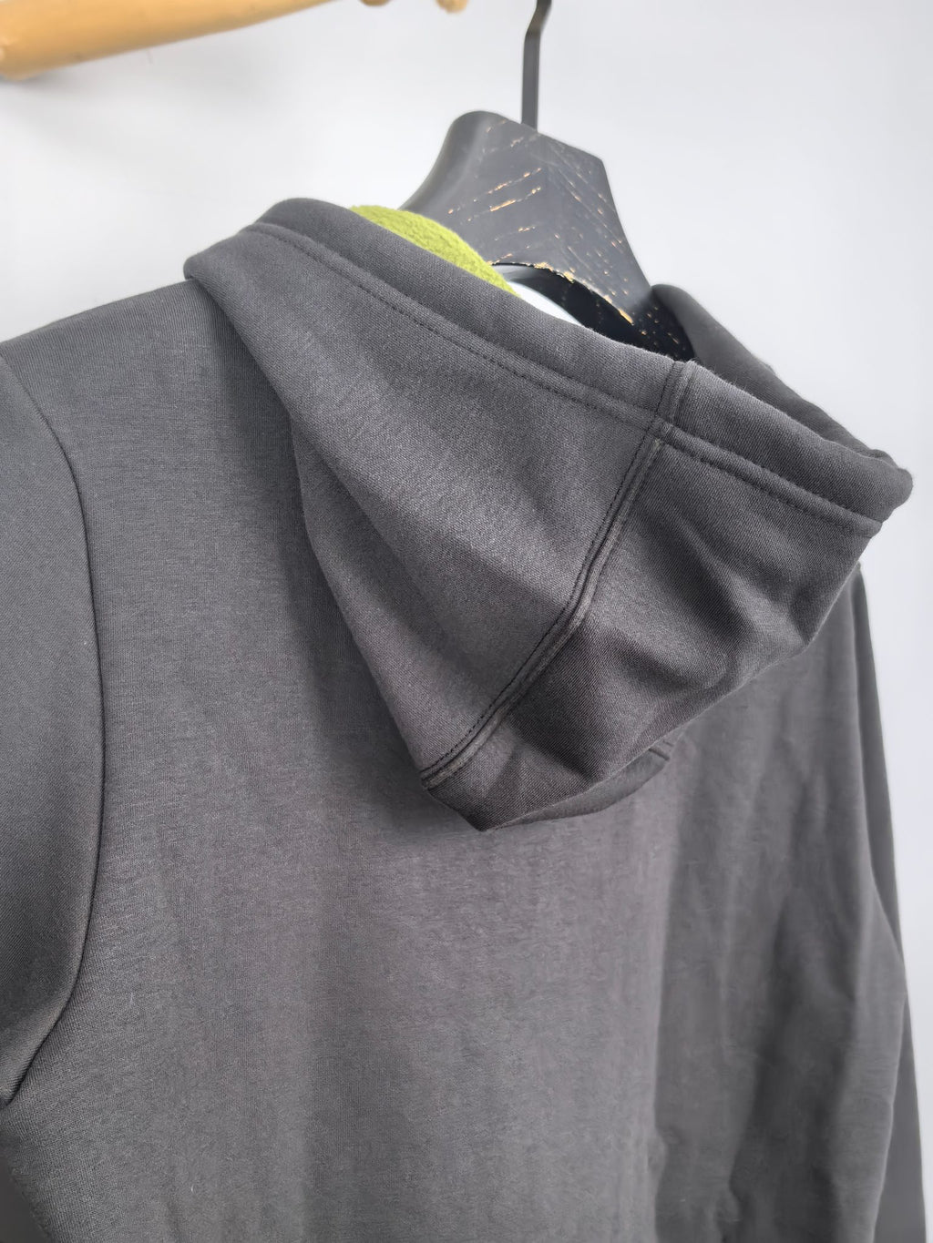 Dark gray zip-up hoodie hood view with neon green inner lining