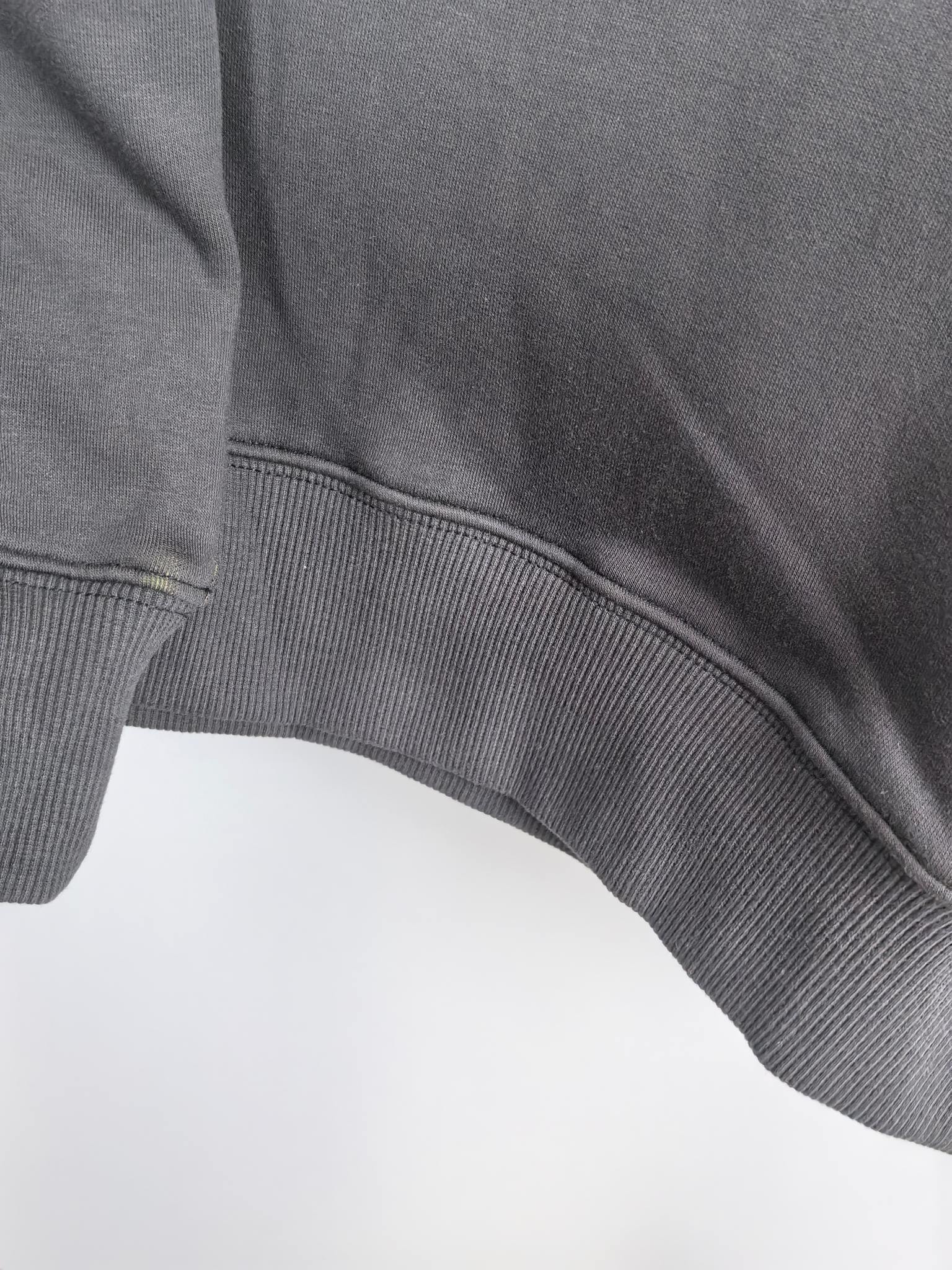 Dark gray hoodie hem with ribbed knit band and curved seam detail