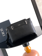 Black Dior men's small crossbody bag with adjustable strap and buckle front.