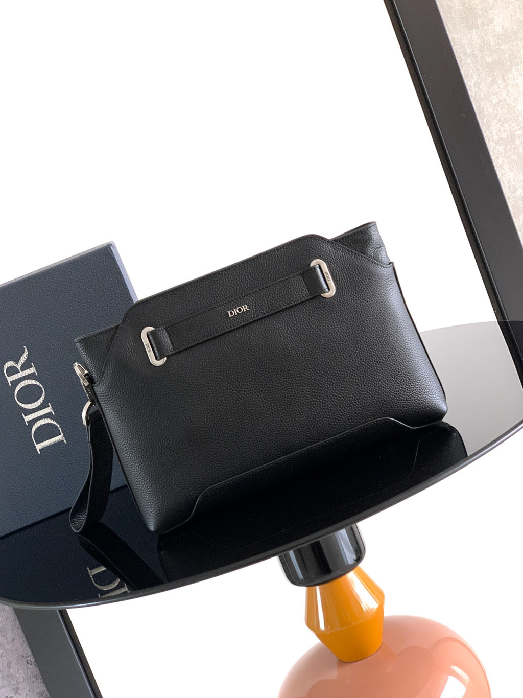 Dior bag in dark leather with front strap and silver buckle.