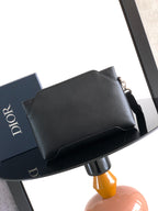 Black Dior men's small bag with structured top flap and side buckle strap.