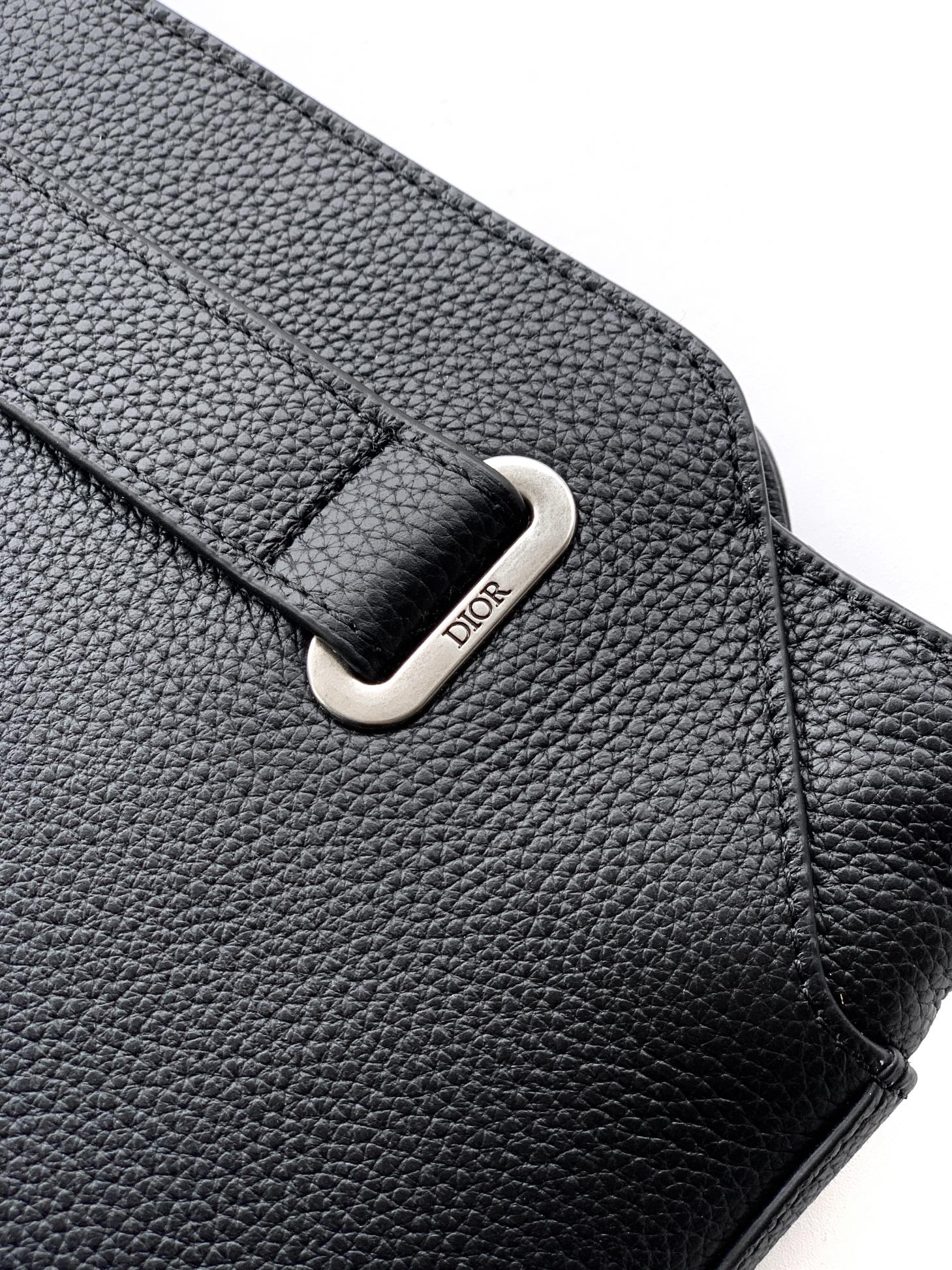 Black Dior leather bag detail with silver-tone logo buckle on flap.