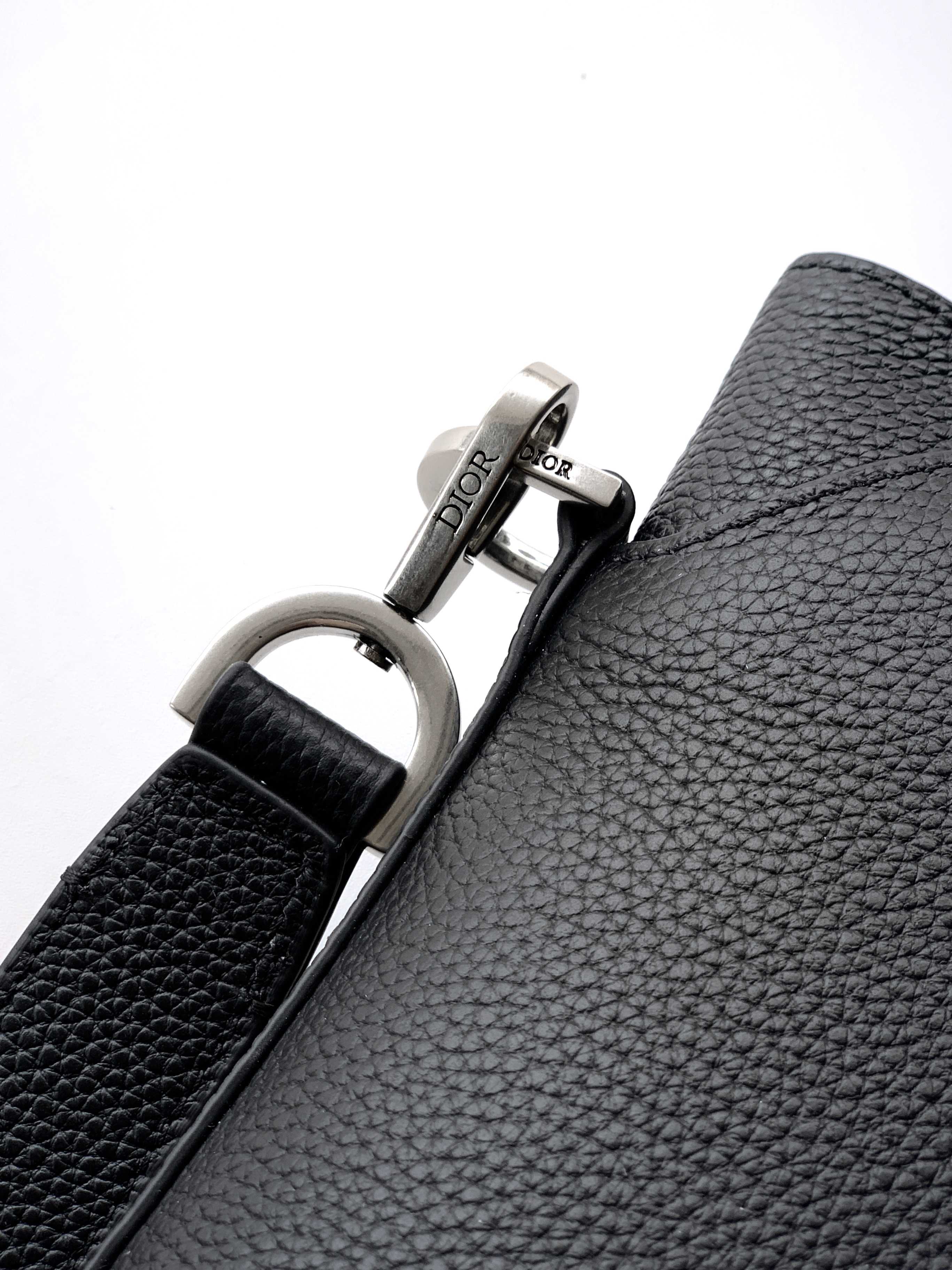 Dior bag strap hardware with silver D-ring and Dior engraved plaque.