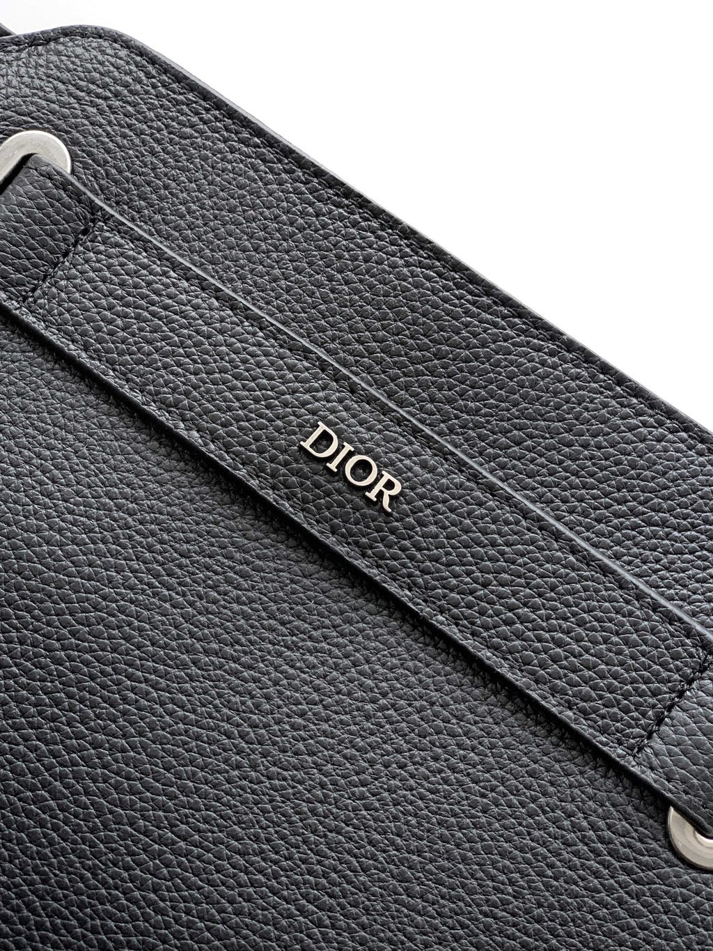 Black Dior leather strap panel with debossed Dior logo and visible stitching.