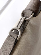 Dior bag close-up of logo-stamped strap and silver D-ring hardware