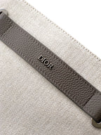 Dior men’s bag close-up of “Dior” logo on dark leather trim along the edge
