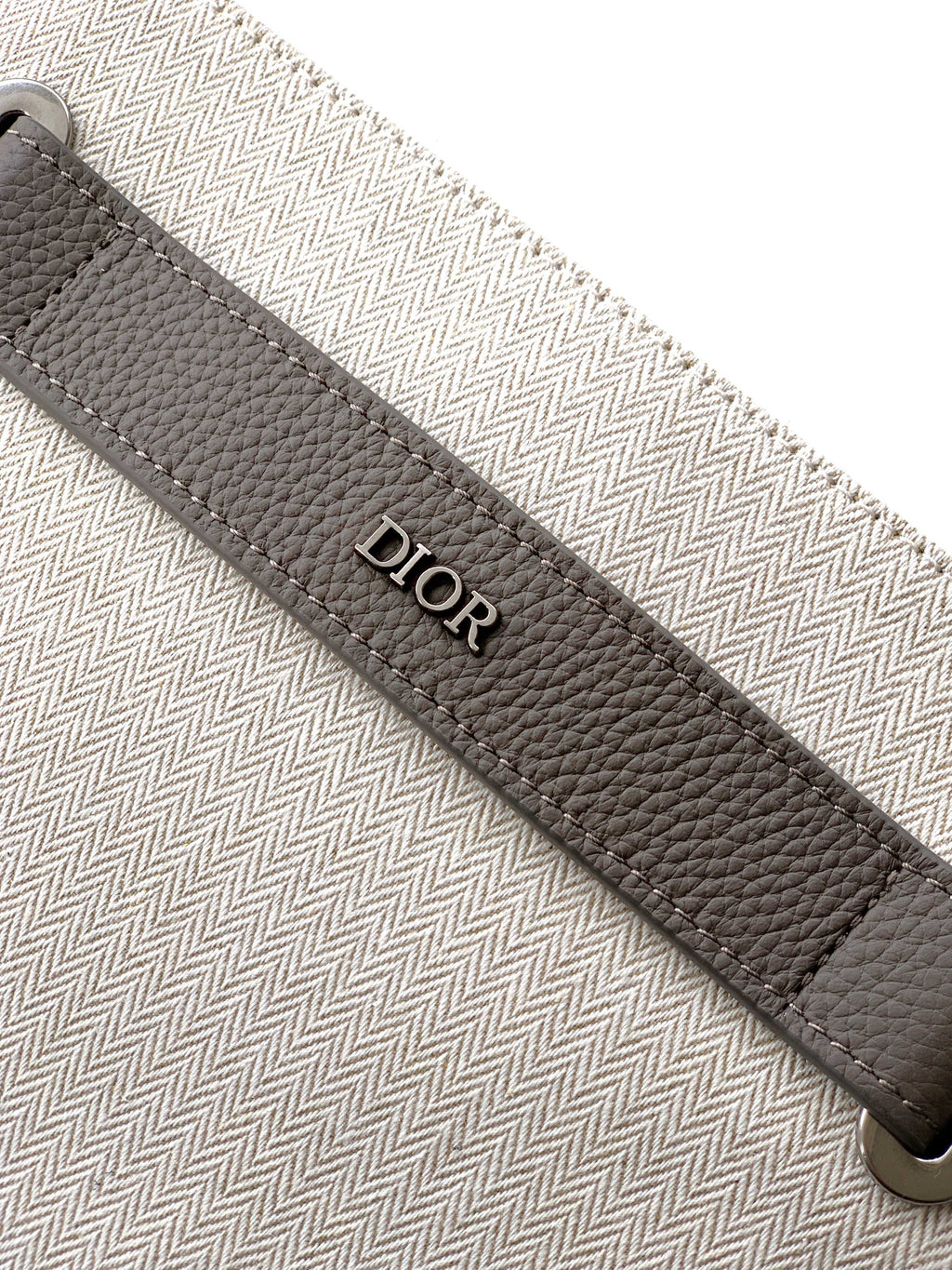 Dior bag strap close-up with Dior logo stamp and stitched trim