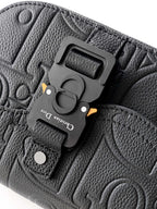 Dark leather crossbody bag with magnetic clasp hardware and embossed pattern