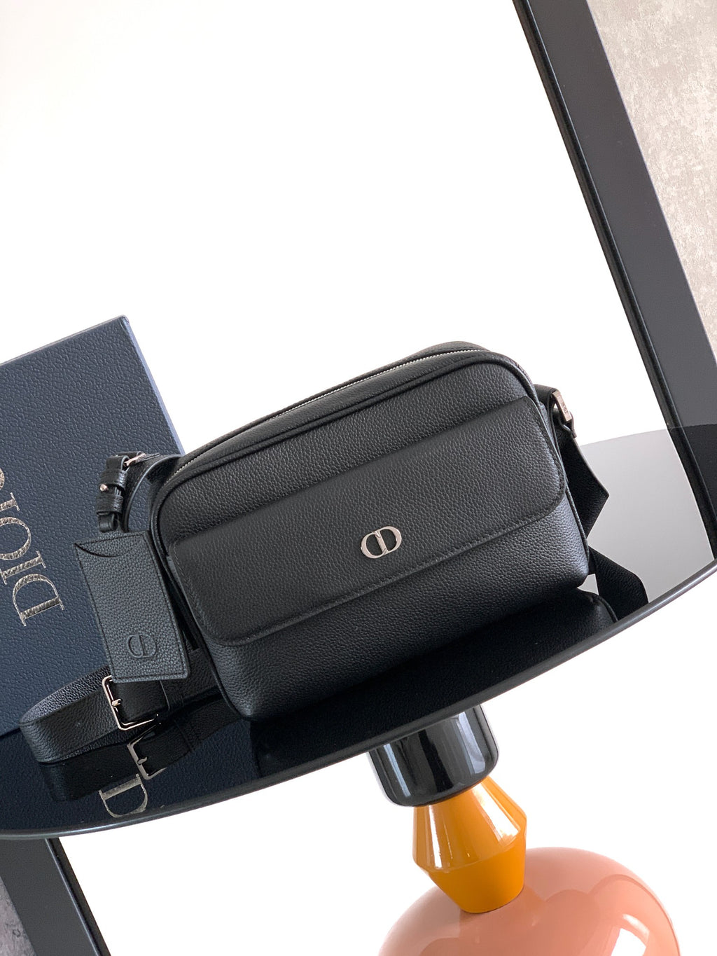Men's Dior crossbody bag in black textured leather with top zipper and front logo