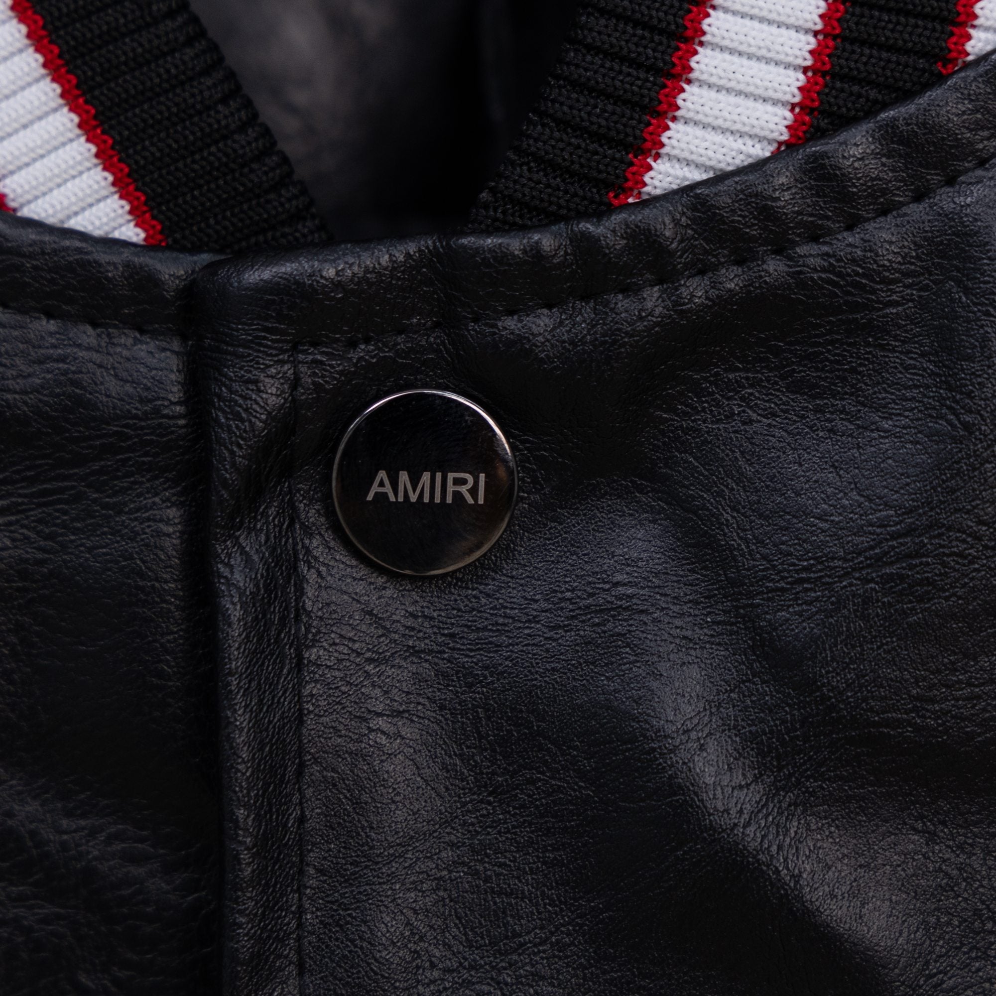 Amiri black leather jacket with round snap button branded “AMIRI”