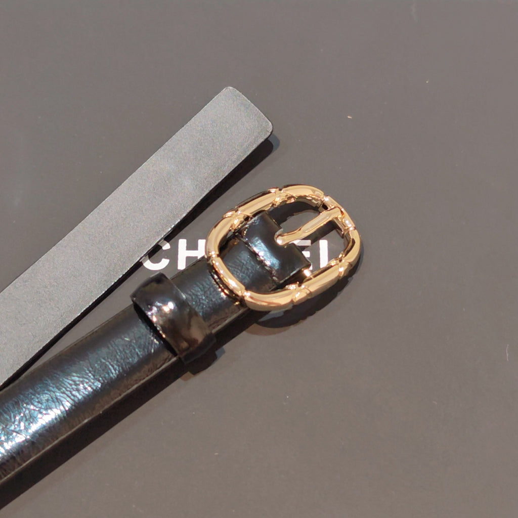 Chanel leather belt buckle close-up, gold-tone oval with black enamel center