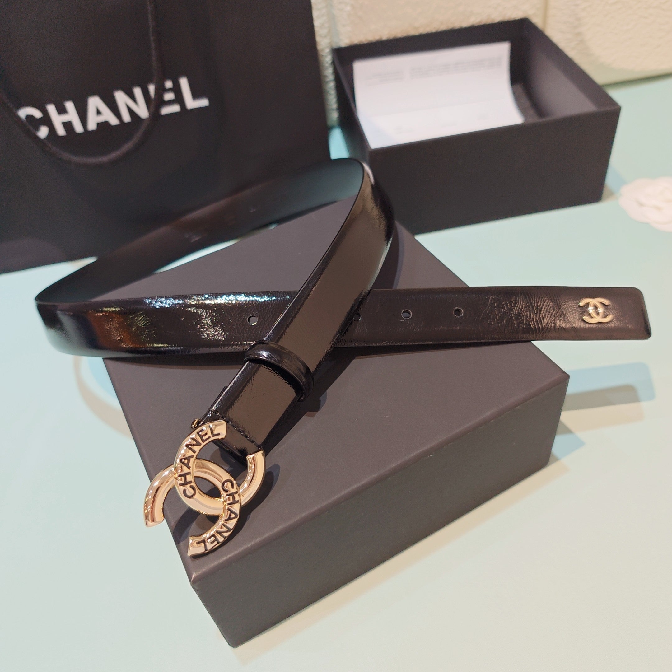 Chanel belt with dark leather strap and gold-toned buckle clasp with interlocking CC