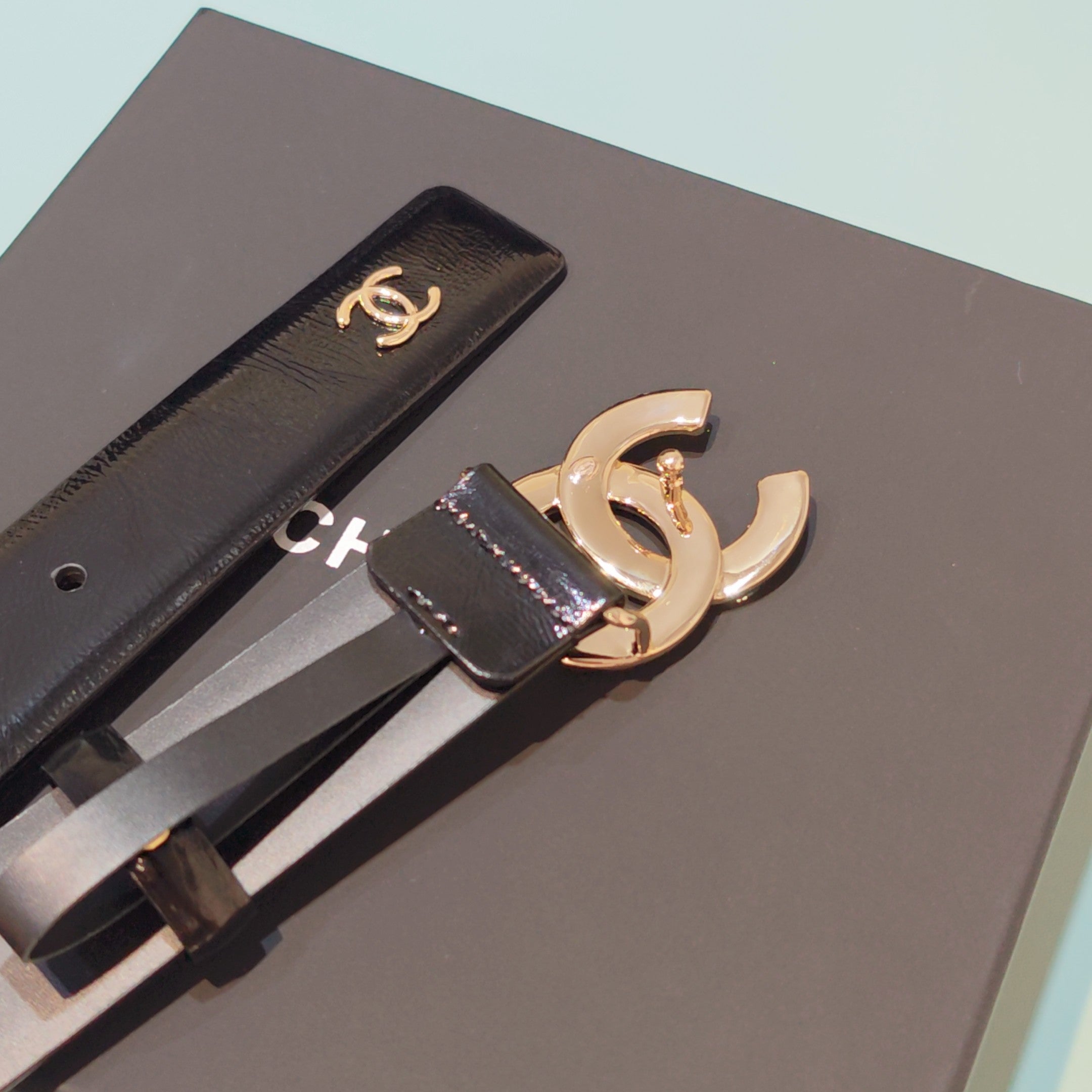 Chanel belt detail: dark leather strap with gold CC buckle and stitched edge