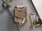 Gucci long-sleeve top with crew neck, white cuffs, and small chest logo