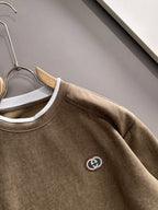 Gucci long-sleeve top close-up of chest logo and white-trim crew neckline