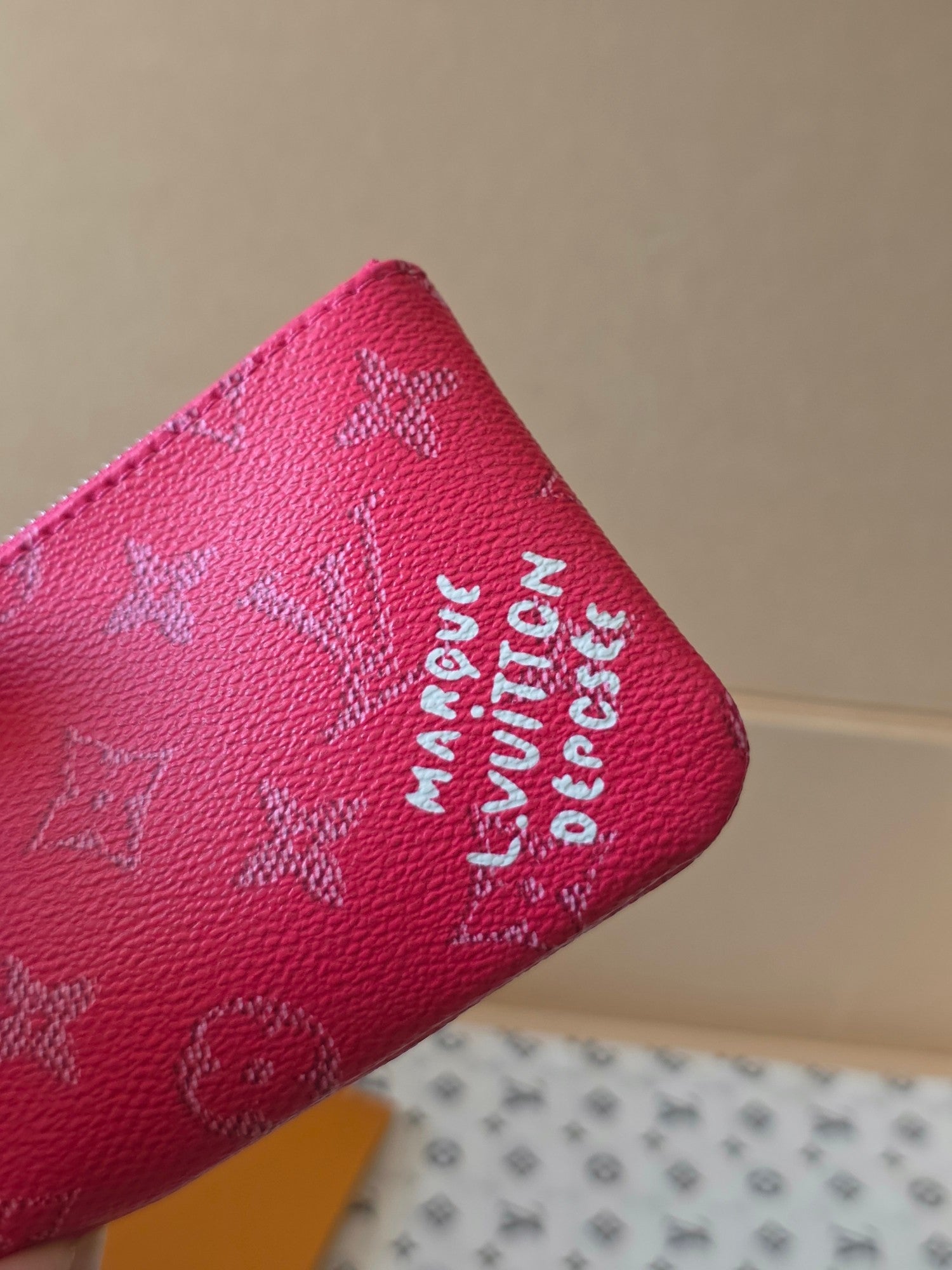 Louis Vuitton pink monogram bag close-up with embossed logo text on the side