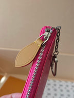 Louis Vuitton pink monogram bag with front zip pull, tan leather tab, and chain hardware