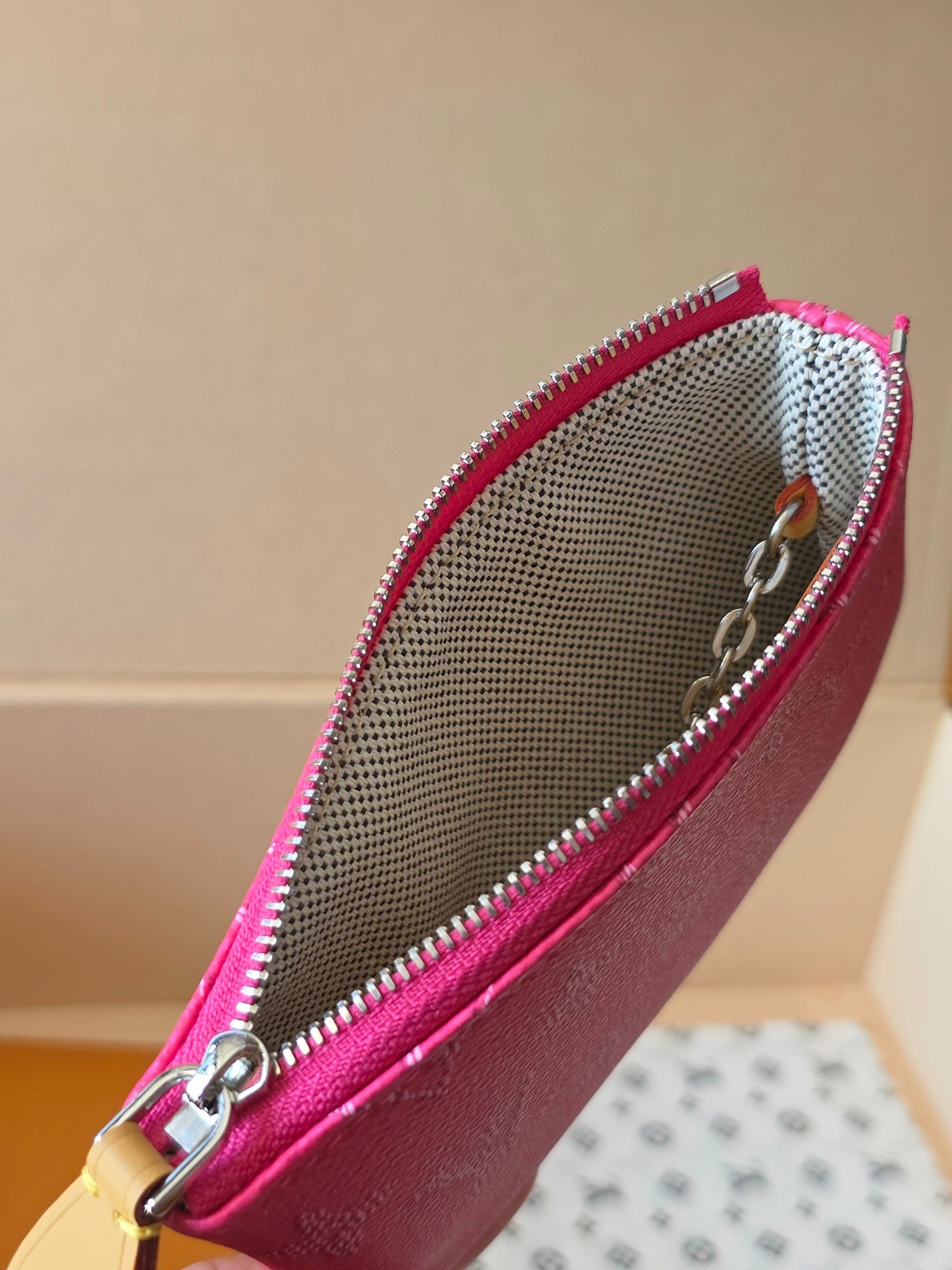 Hot pink Louis Vuitton small bag open view with woven lining and zipper trim