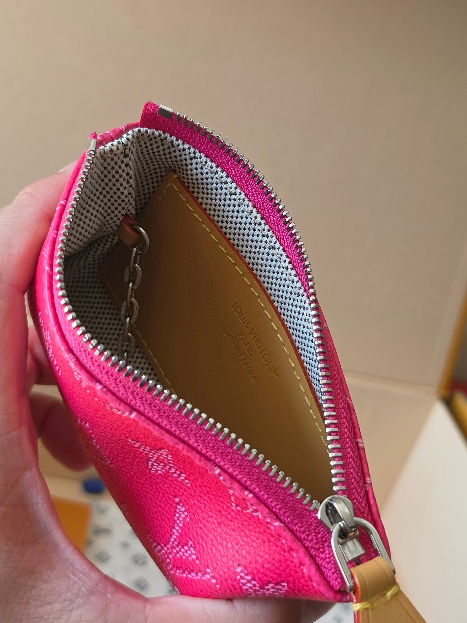 Hot pink Louis Vuitton small bag interior view with brown lining and zip pocket