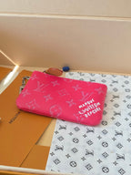 Hot pink Louis Vuitton small bag with zip top and monogram pattern, flat lay