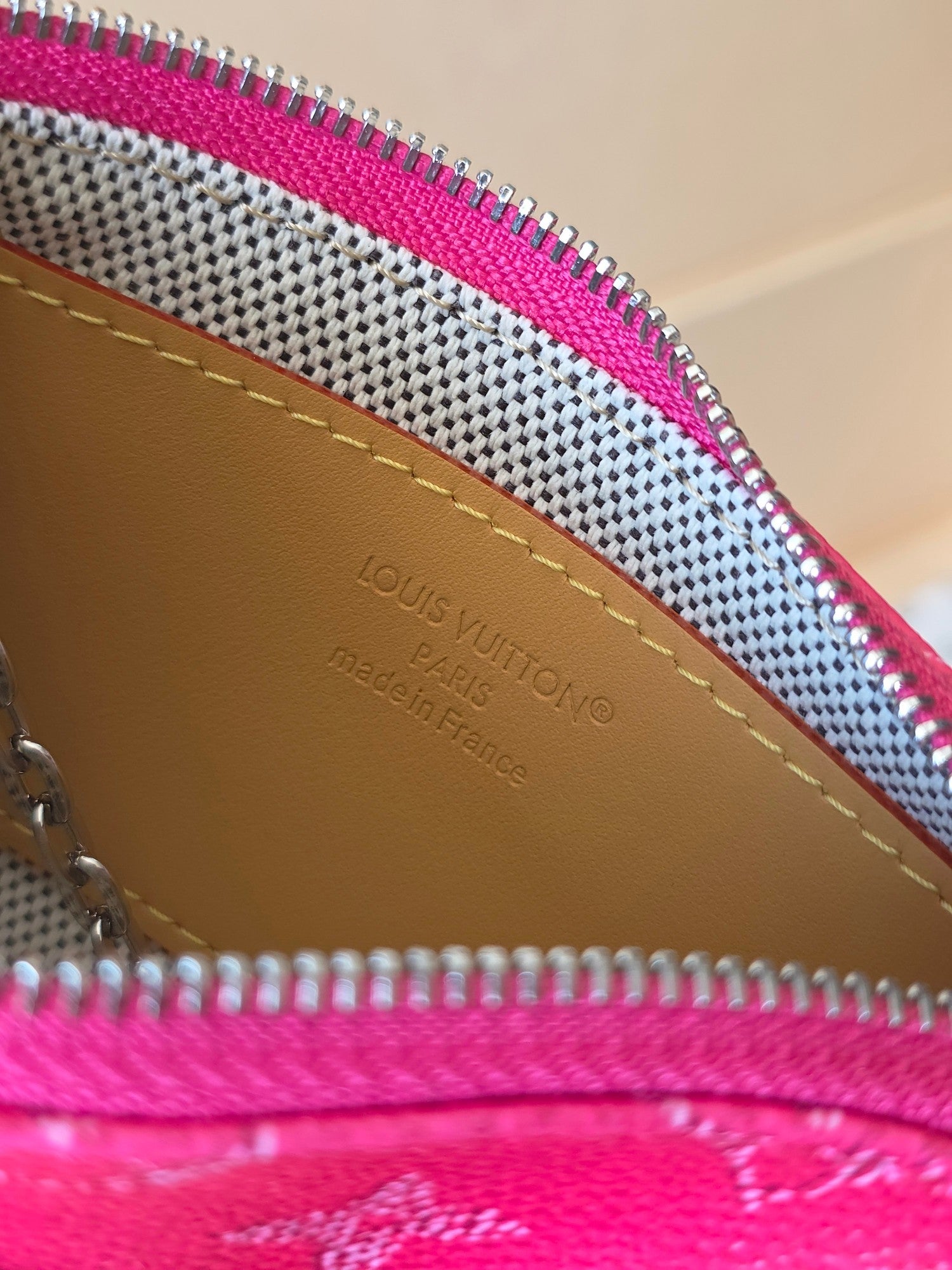 Louis Vuitton pink monogram bag interior close-up with tan leather trim and text