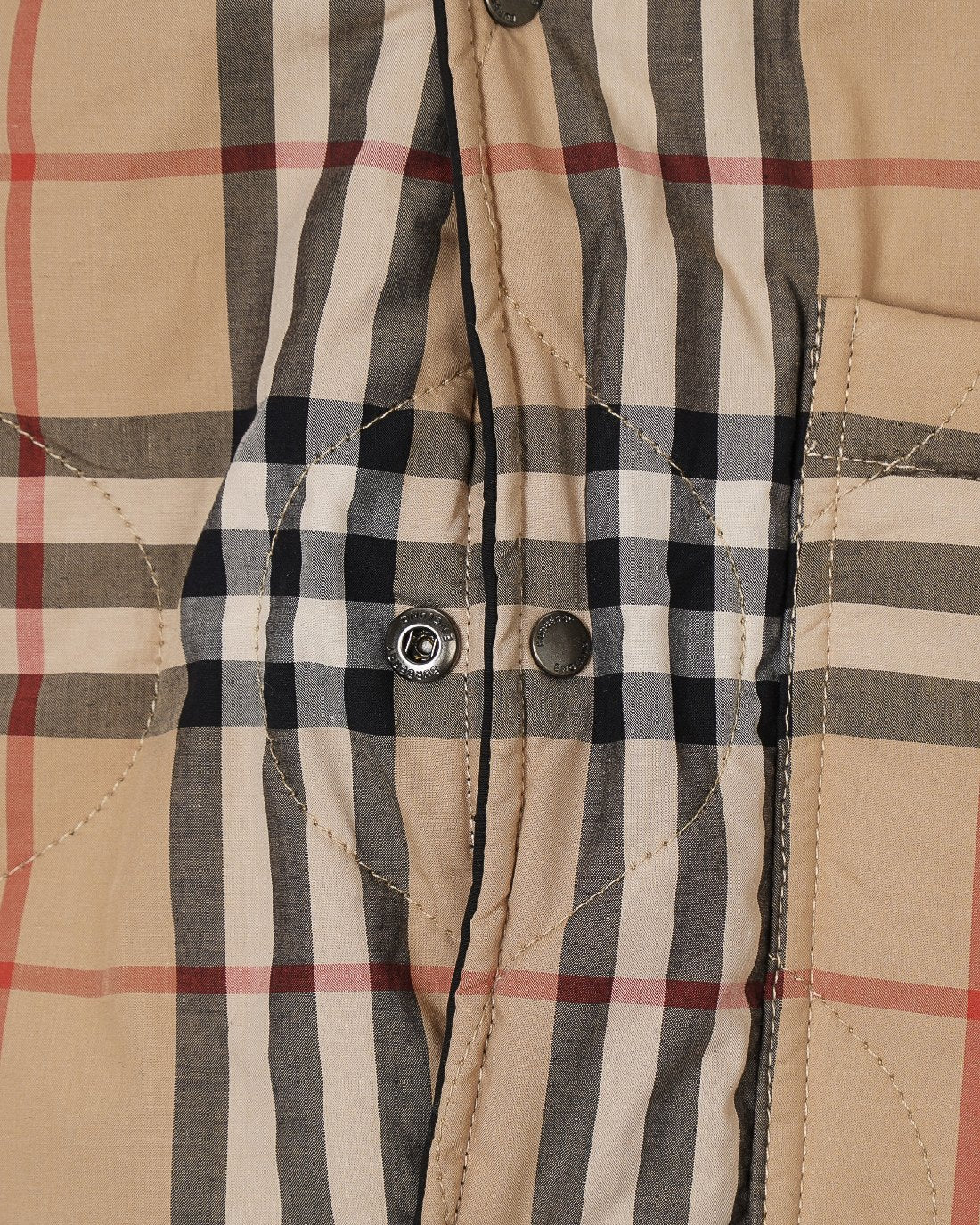 Burberry plaid jacket front placket with two buttons and quilted stitching, beige check
