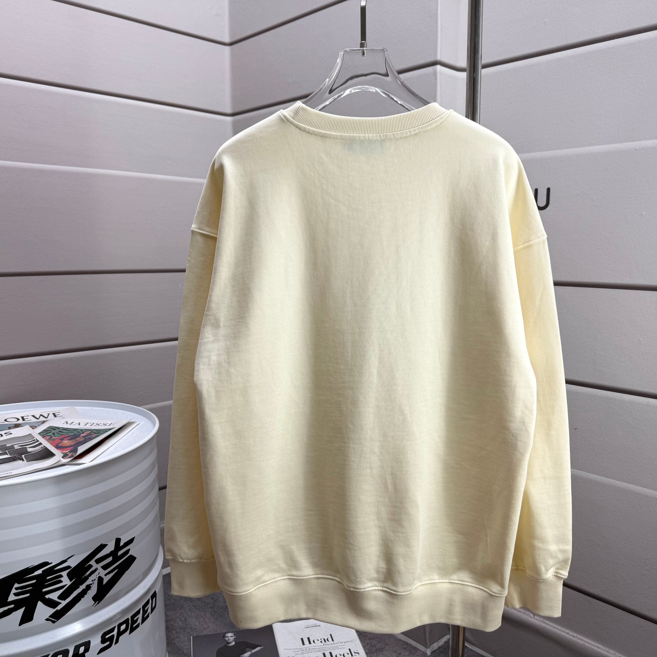 Moncler crewneck sweatshirt in light cream, back view on a hanger
