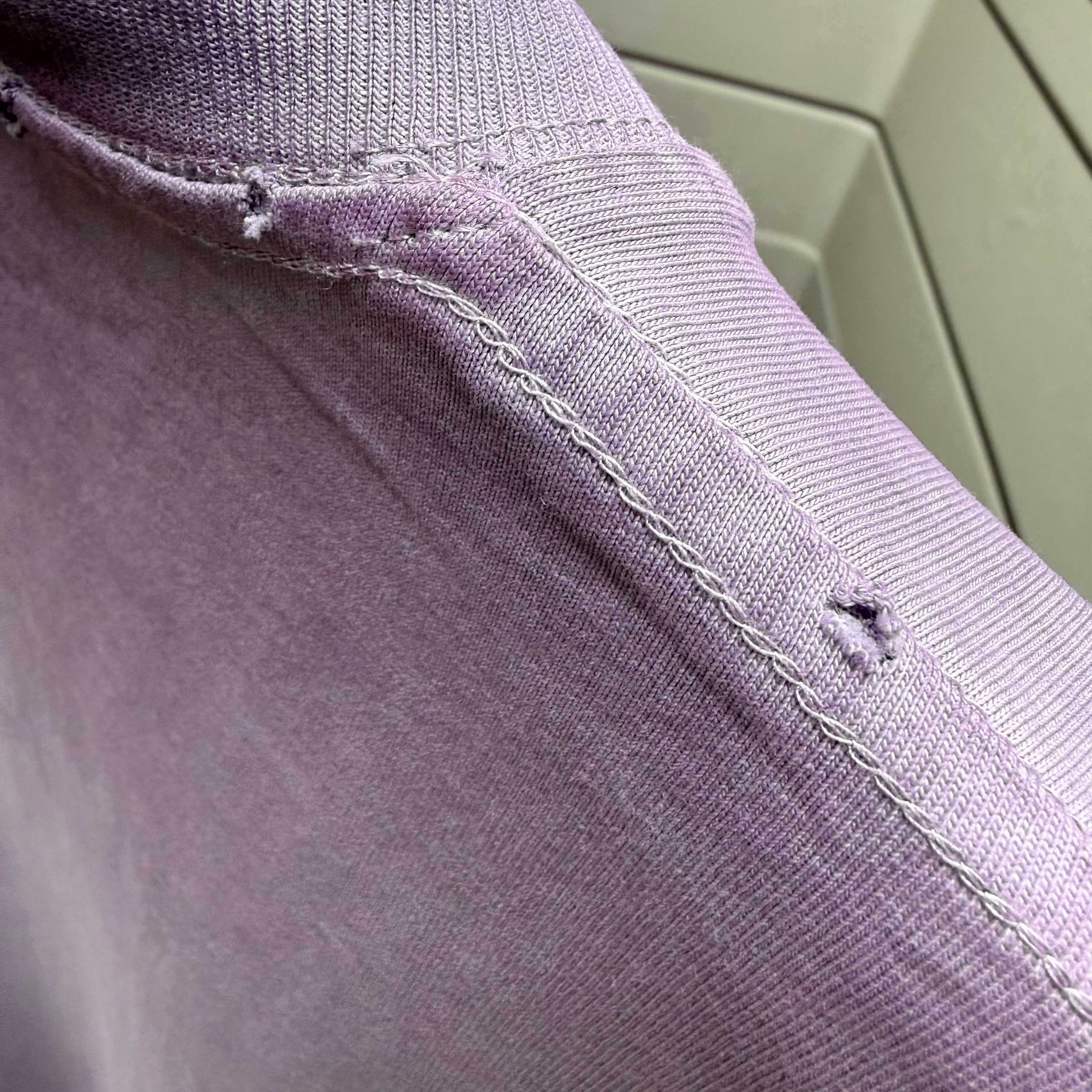 Lavender T-shirt collar seam with stitched detailing along ribbed trim