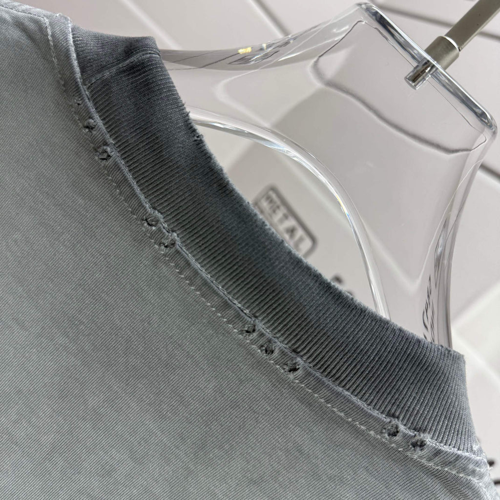 Muted gray-green T-shirt neckline with stitched trim along the collar edge