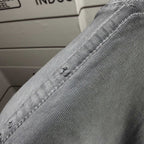 Gray T-shirt shoulder seam with stitched detail near neck rib