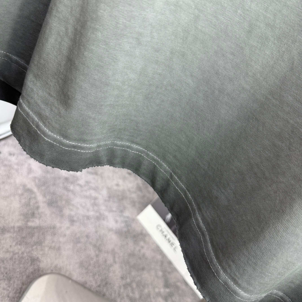 Muted gray-green T-shirt bottom hem with stitched finish