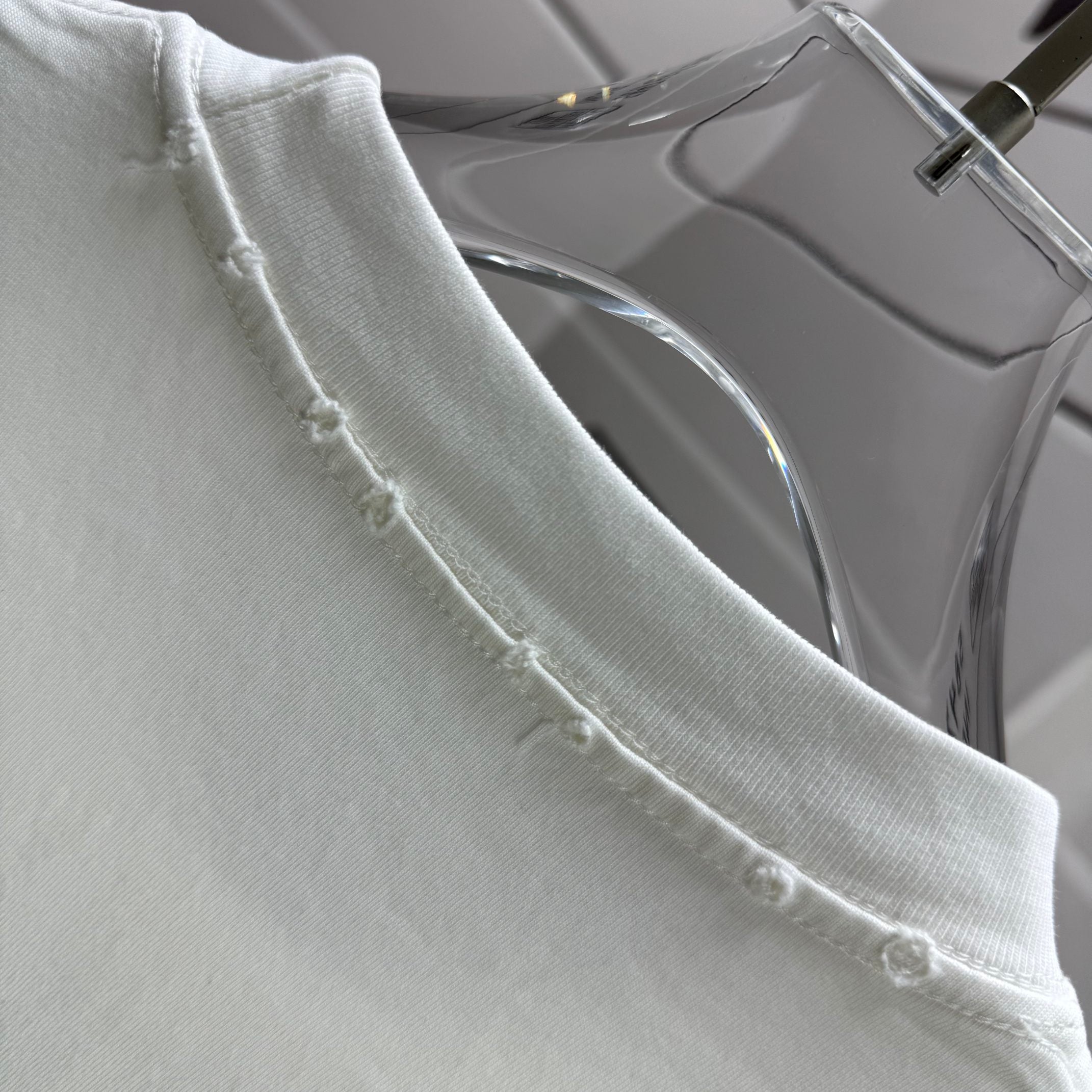 White T-shirt raw hem detail with stitched edges