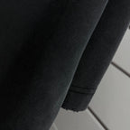 Black T-shirt fabric seam and hem detail, close-up