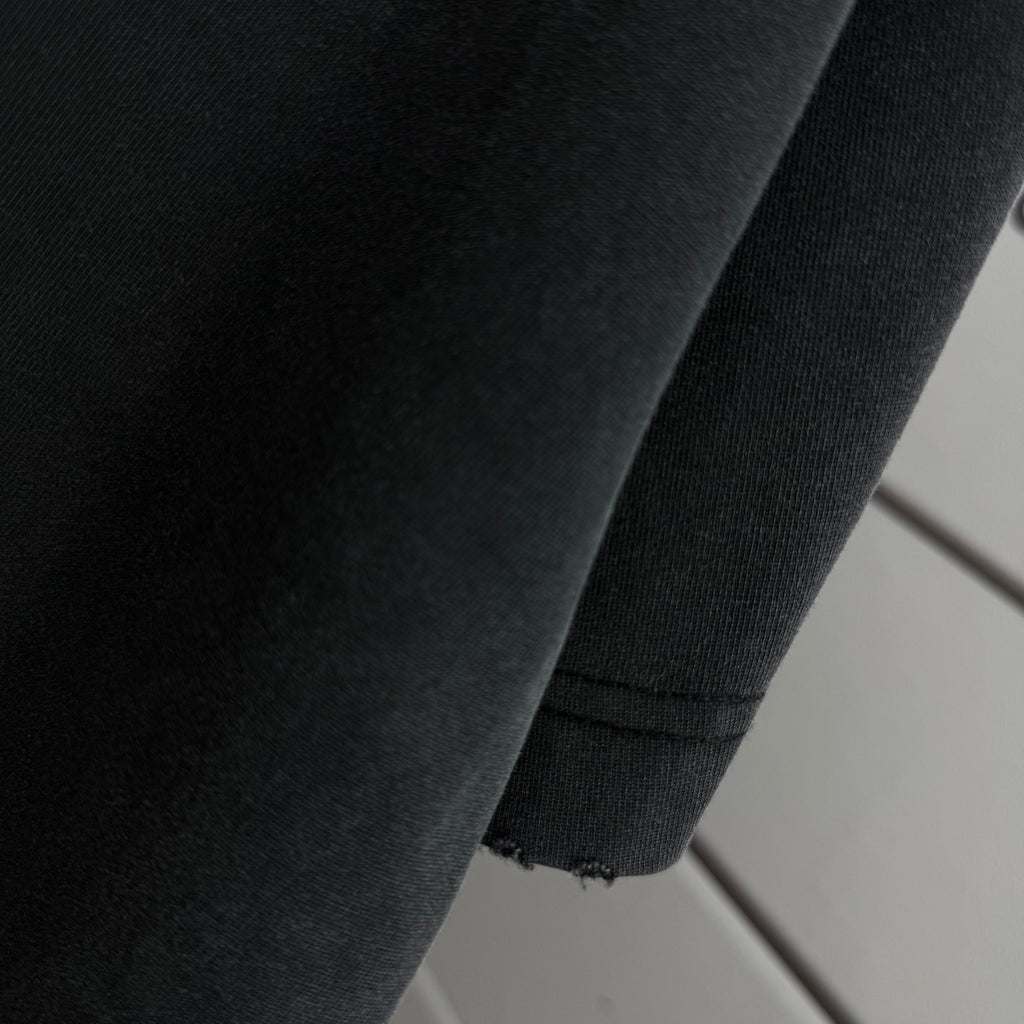 Black Off-White T-shirt fabric close-up with stitched seam detail