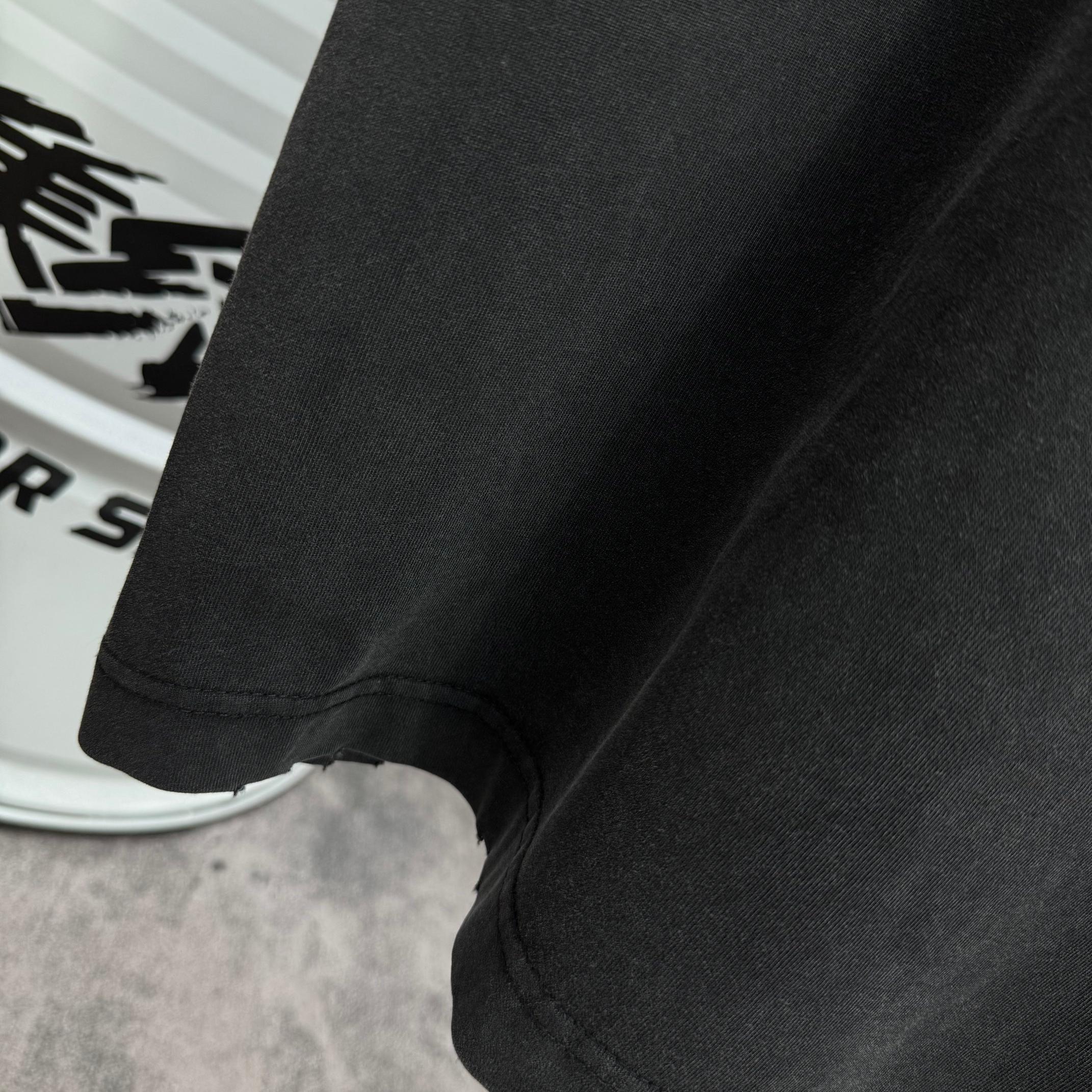 Black T-shirt curved hem and side seam, close-up