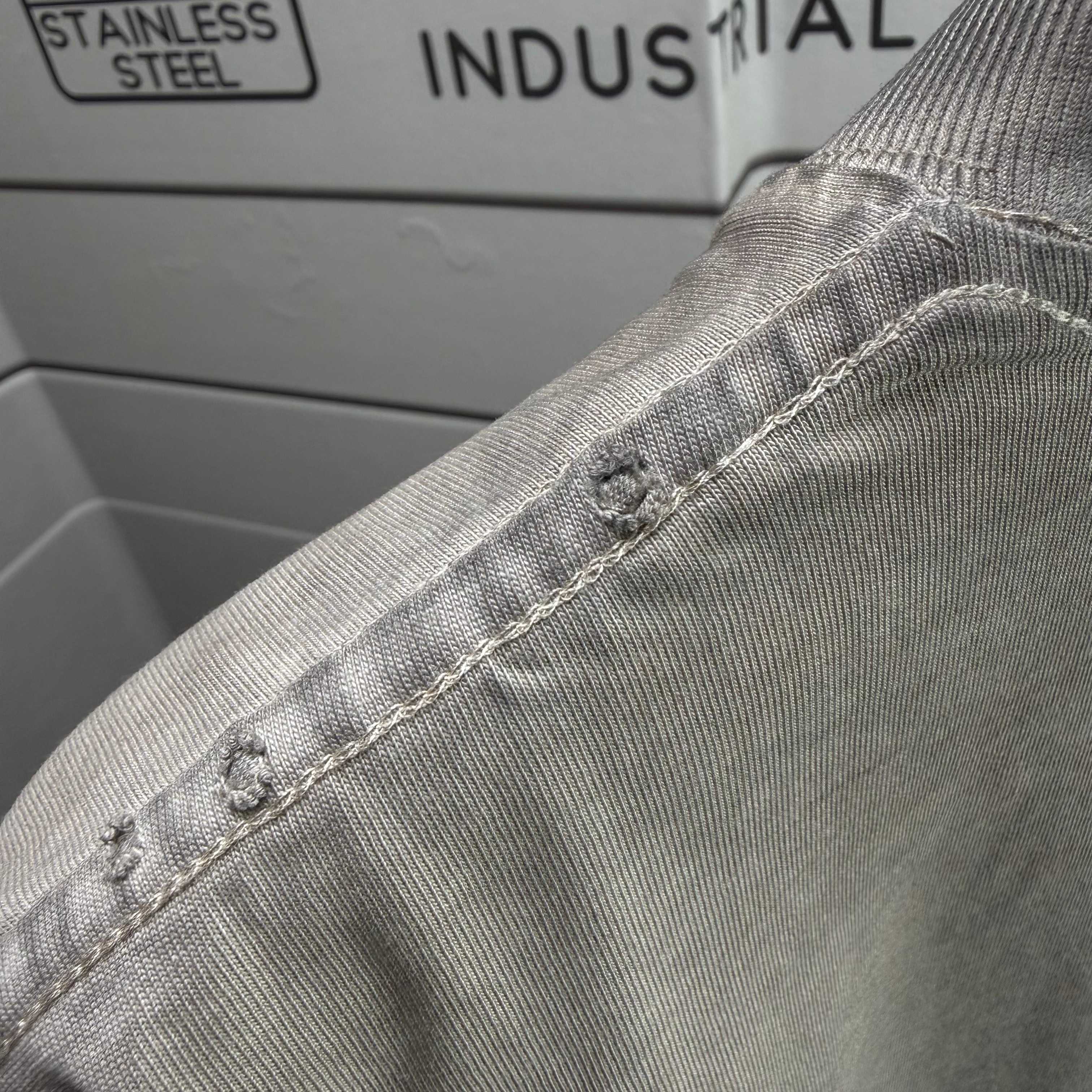 Gray T-shirt collar seam with small button detail