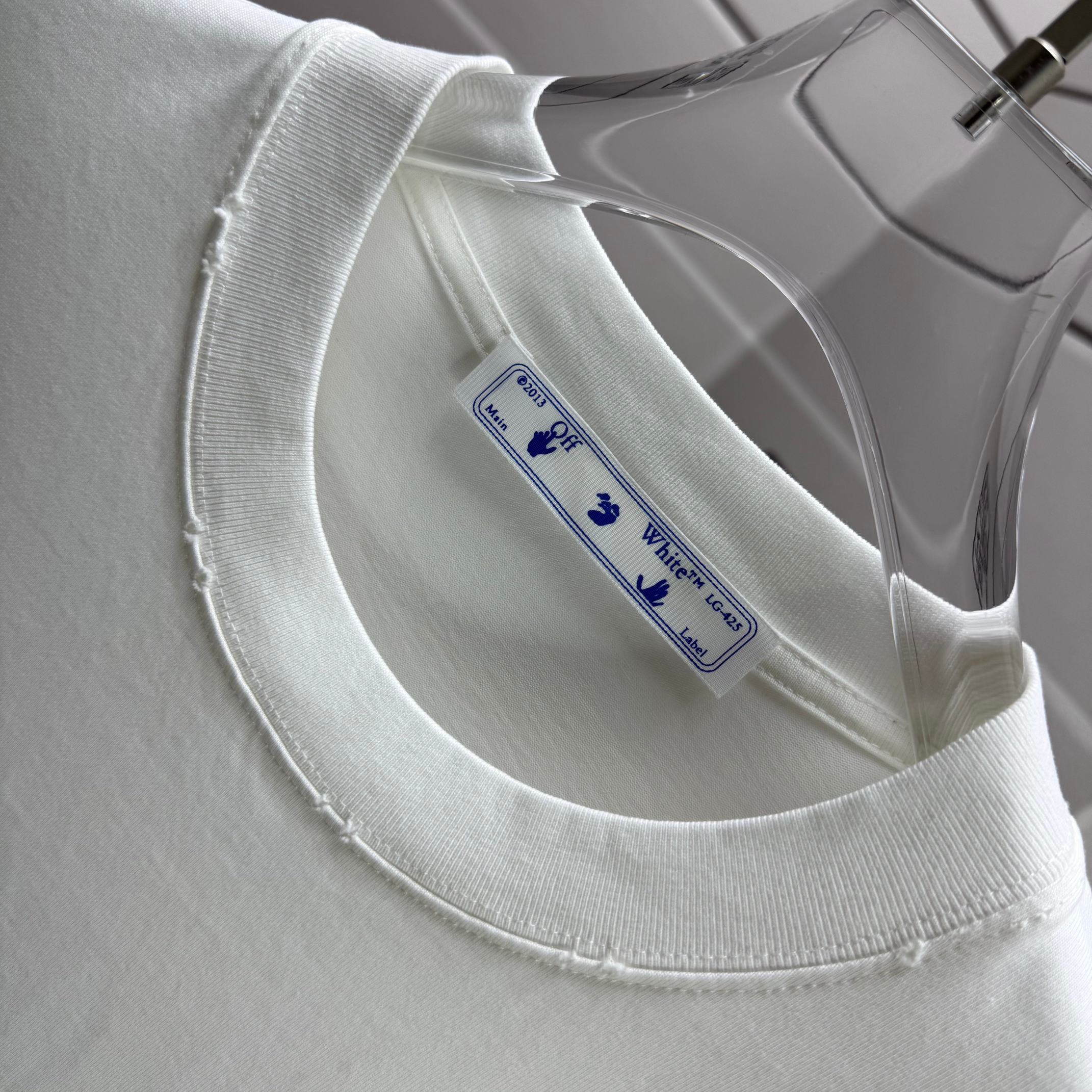 Off-white T-shirt close-up of crew neck seam and inner size label