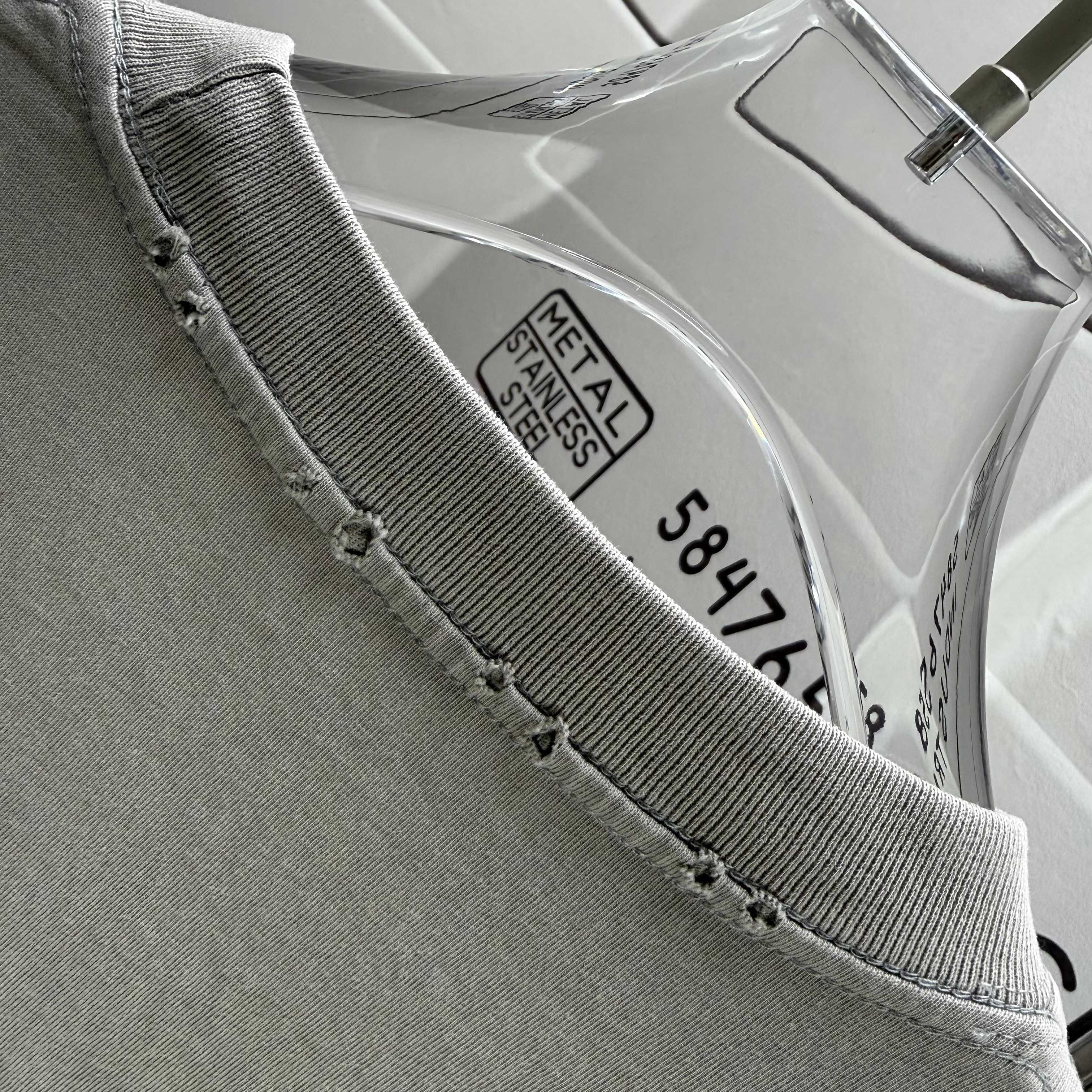 Gray T-shirt collar edge with inner woven label and reinforced stitching