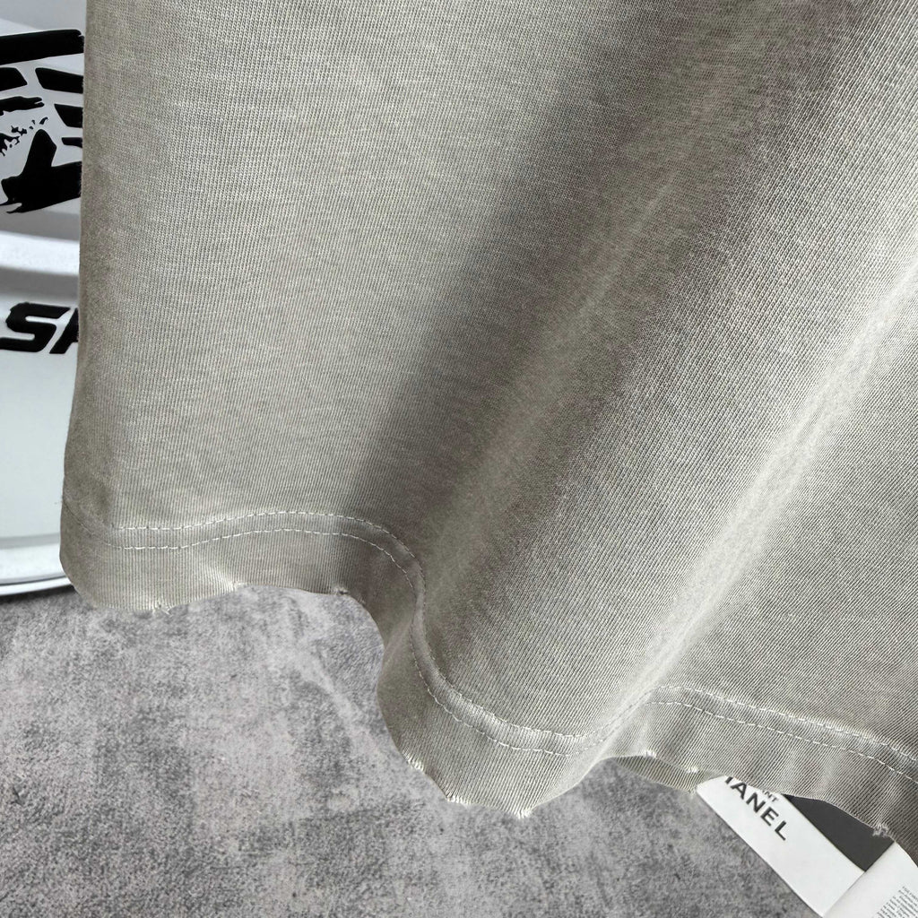 Light gray T-shirt bottom hem with attached size label